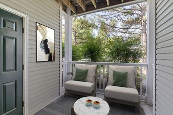 A small balcony with a table and two chairs.